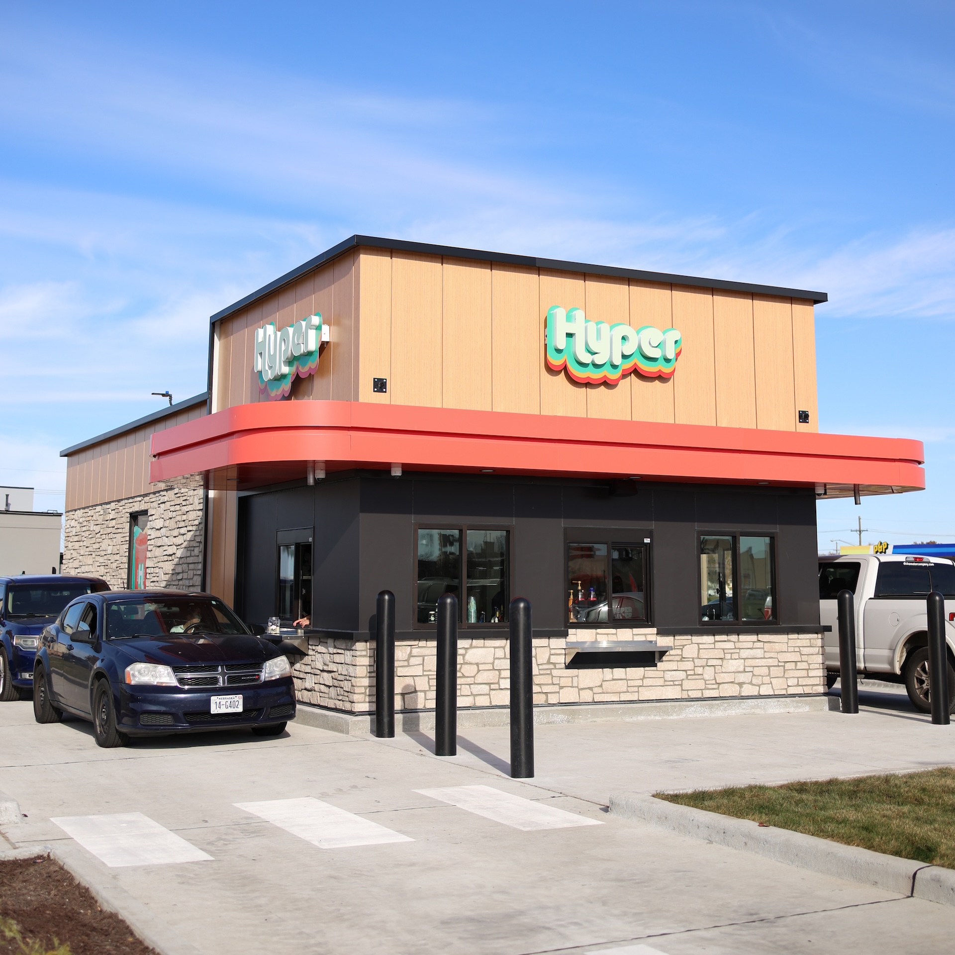 Hyper Energy Bar building exterior with vehicles on both sides using the drive-thru
